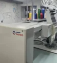 Máquina de bordar industrial Tajima com a marca Camisetas Rápido na fábrica de São Paulo.