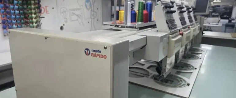 ordado industrial Camisetas Rápido Máquina de bordar industrial Tajima com a marca Camisetas Rápido na fábrica de São Paulo.